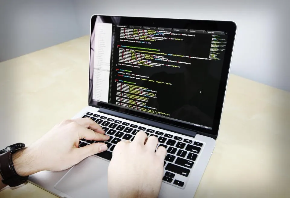 Manos programando en un portátil